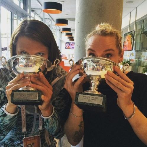 Safarova and Mattek Sands drinking champagne from their Roland Garros trophy 2015