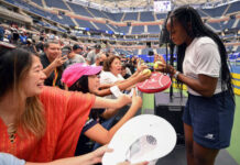 Coco Gauff signs tennis balls during the 2022 US Open Fan Week