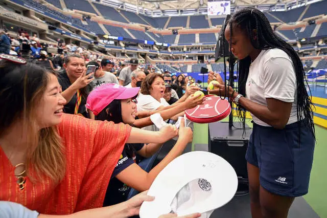Coco Gauff signs tennis balls during the 2022 US Open Fan Week