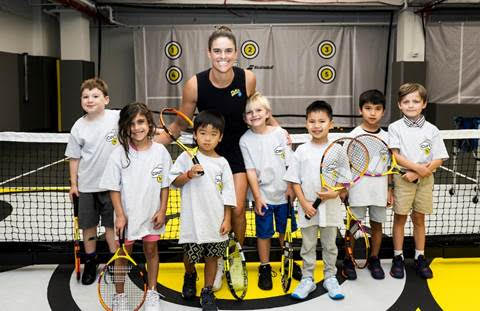 Jennifer Brady poses with kids at the Babolat event