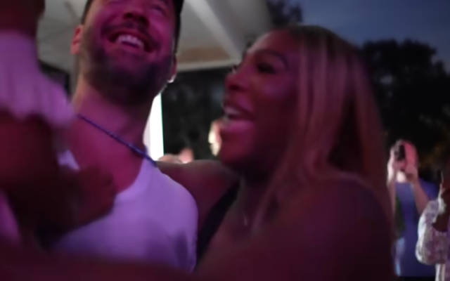 Serena Williams smiles and kisses her husband during the gender reveal party
