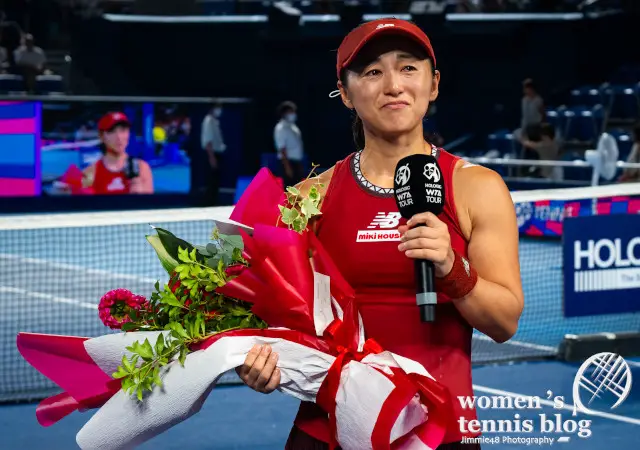 Misaki Doi receives a flower bouquet after playing the last match of her career