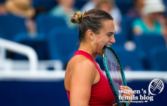 Aryna Sabalenka bites her tennis racquet in Cincinnati