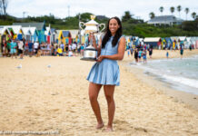 Madison Keys poses with her Australian Open trophy on the beach