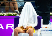 Iga Swiatek covers her head with a towel at the Qatar Total Open in Doha